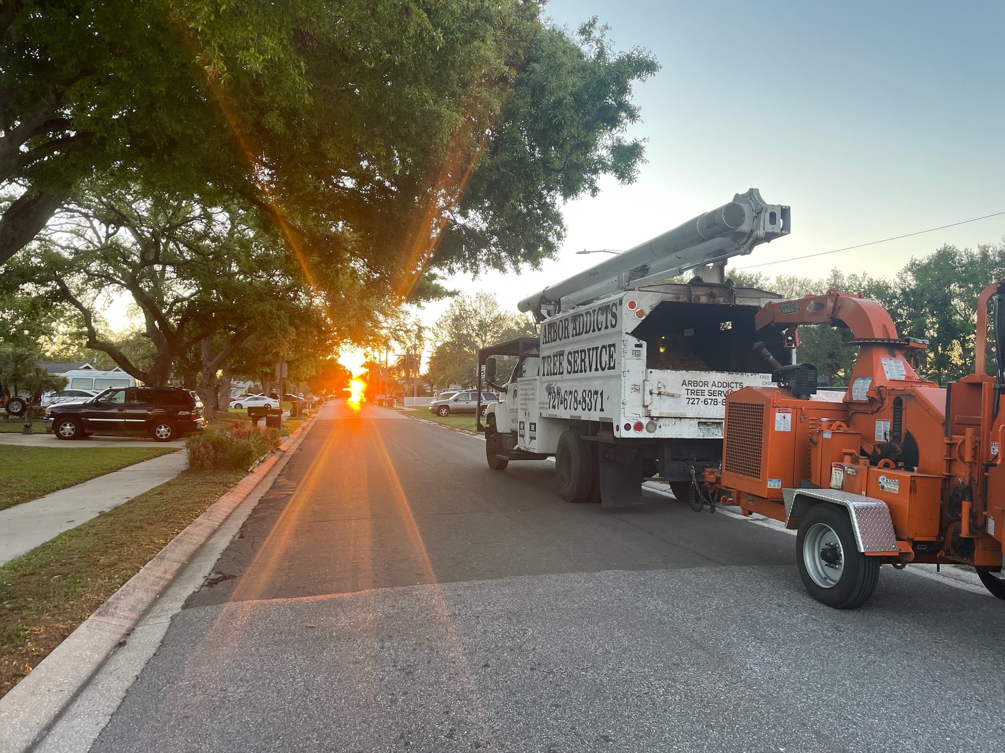 Arbor Addicts Tree Service truck and chipper on a residential street